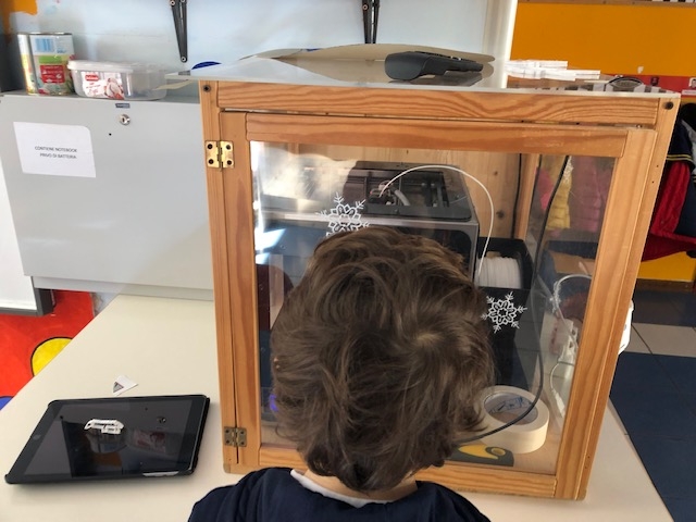 Un bambino osserva la stampa dell'oggetto da lui progettato  